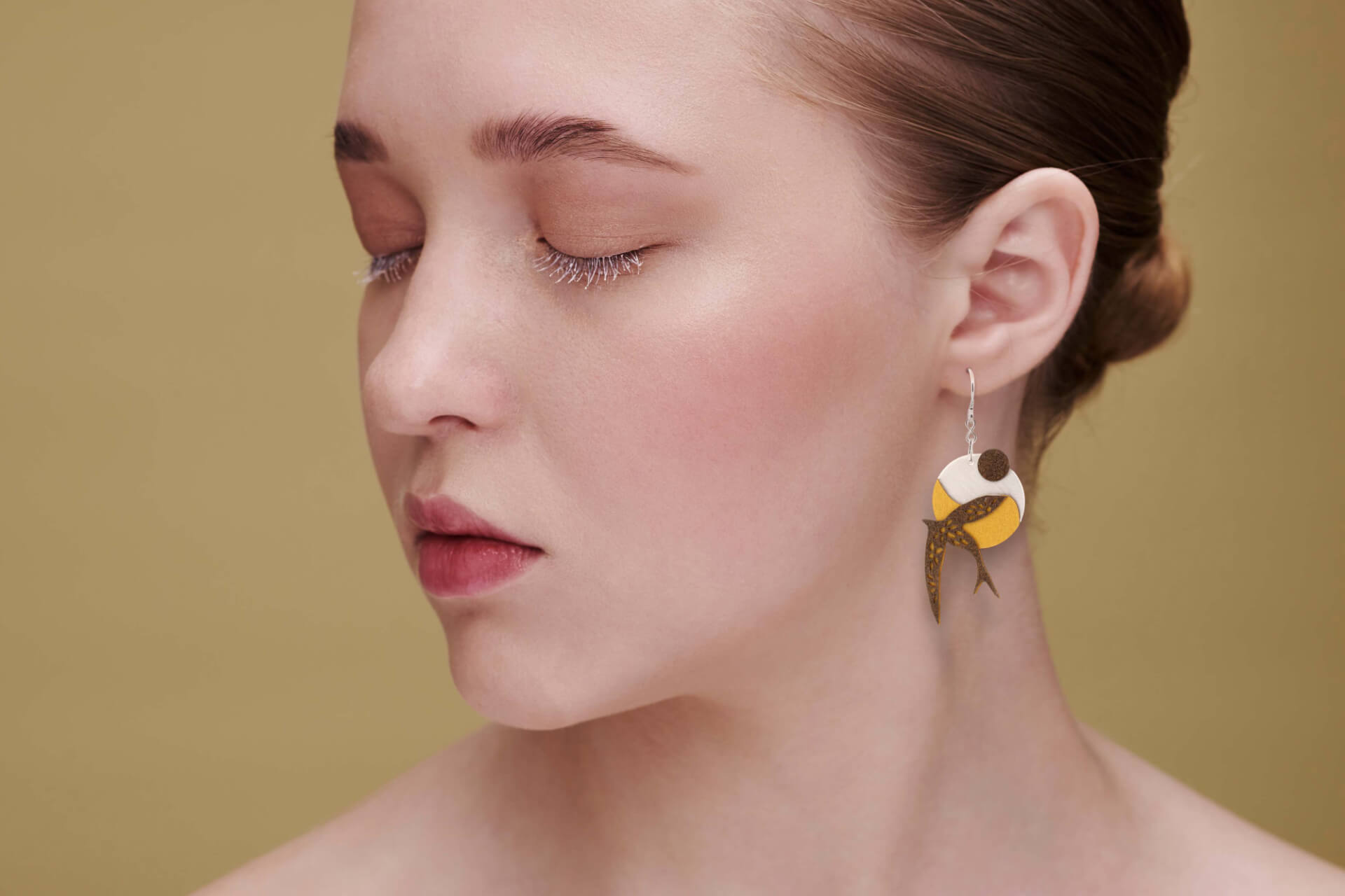 Pendientes gancho golondrina dorado artesanal bañado en plata, elaborado por Joyas de Papel